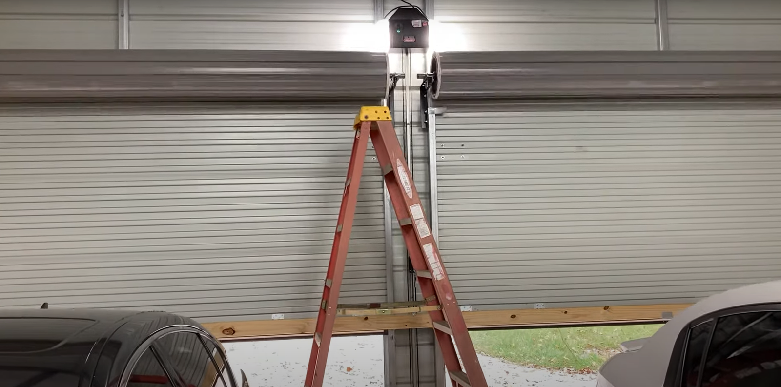 Garage door installation team securing heavy-duty door panels for a commercial garage