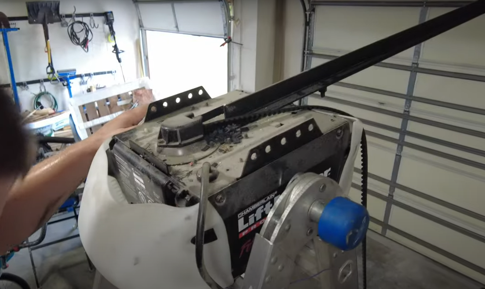 "Technician installing a modern garage door opener on a residential garage, showcasing tools and precision work."
