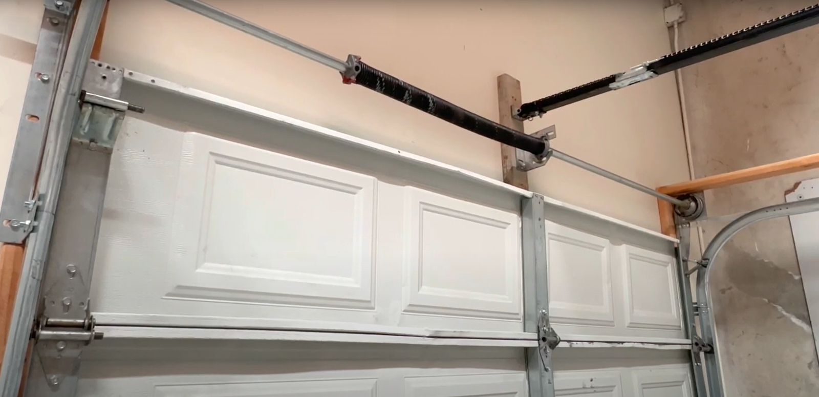 Professional technician repairing a high-tension garage door spring safely in Laurel, Florida.