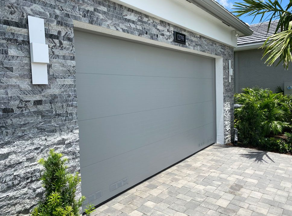 Standard residential garage door lacking wind-load reinforcement