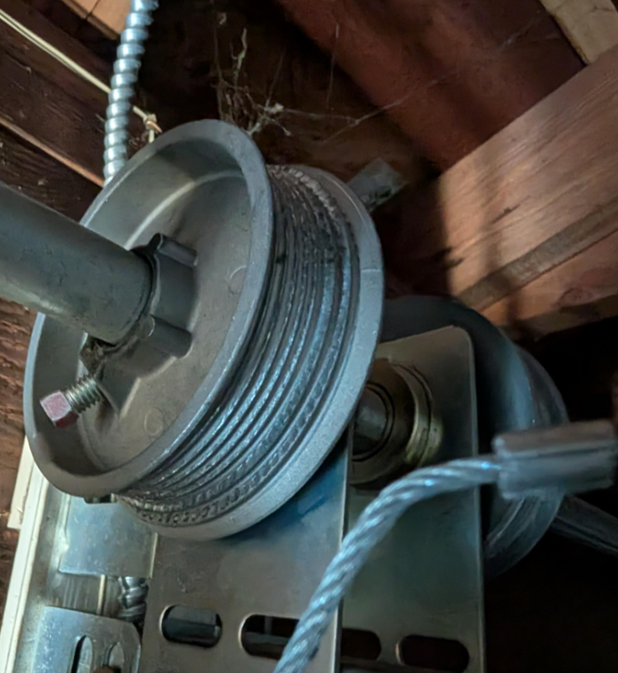 Frayed or misaligned garage door cables showing wear