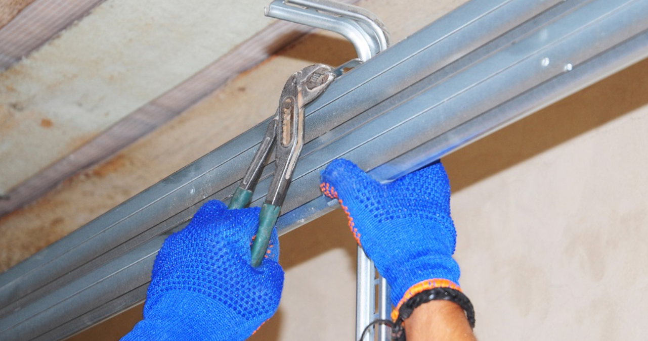 Professional garage door technician performing safety alignment